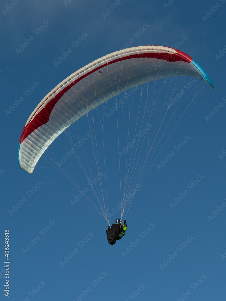 A beautiful view of a paraglide flying gliding on a clear blue sky at the golden hour with a nice wind windy breeze on a sunny day A beautiful view of a paraglide flying gliding on a clear blue sky at the golden hour with a nice wind windy breeze on a sunny day