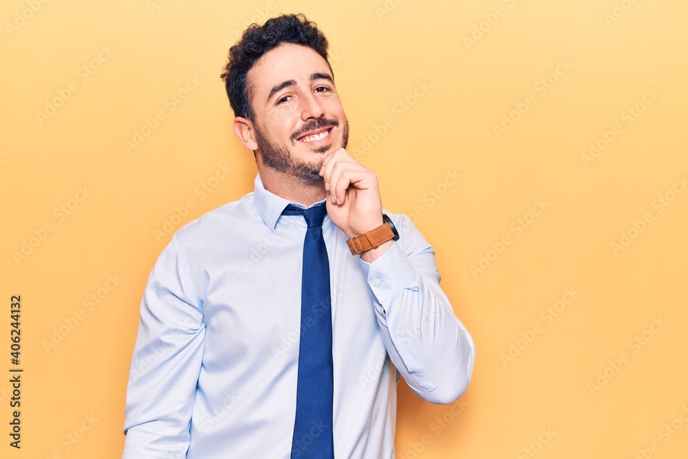 Young hispanic man wearing business clothes smiling looking confident at the camera with crossed arms and hand on chin. thinking positive. Young hispanic man wearing business clothes smiling looking confident at the camera with crossed arms and hand on chin. thinking positive.