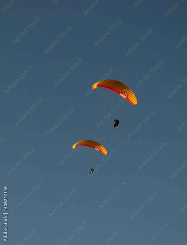 A beautiful view of a paraglide flying gliding on a clear blue sky at the golden hour with a nice wind windy breeze on a sunny day A beautiful view of a paraglide flying gliding on a clear blue sky at the golden hour with a nice wind windy breeze on a sunny day