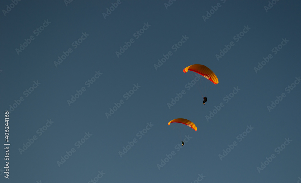 A beautiful view of a paraglide flying gliding on a clear blue sky at the golden hour with a nice wind windy breeze on a sunny day A beautiful view of a paraglide flying gliding on a clear blue sky at the golden hour with a nice wind windy breeze on a sunny day