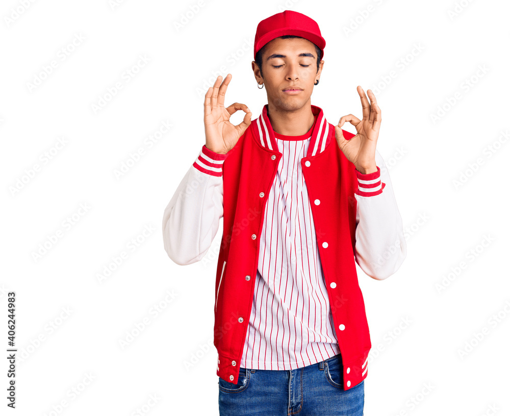 Young african amercian man wearing baseball uniform relax and smiling with eyes closed doing meditation gesture with fingers. yoga concept. Young african amercian man wearing baseball uniform relax and smiling with eyes closed doing meditation gesture with fingers. yoga concept.