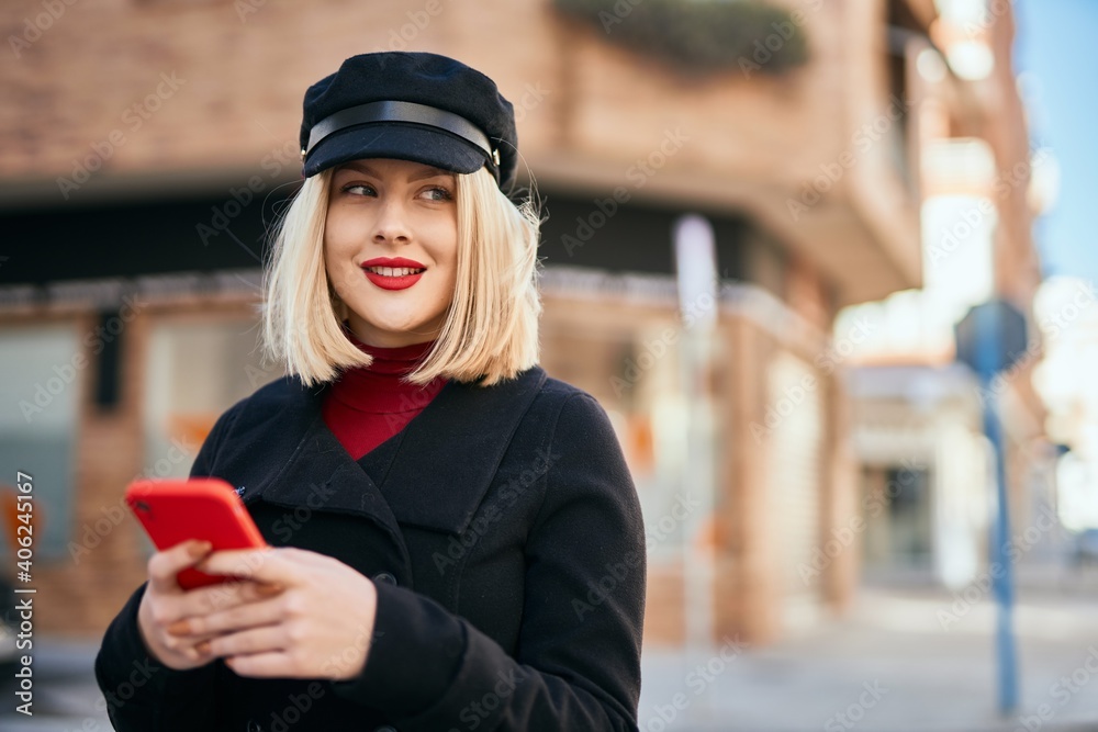 Young blonde woman smiling happy using smartphone at the city. Young blonde woman smiling happy using smartphone at the city.