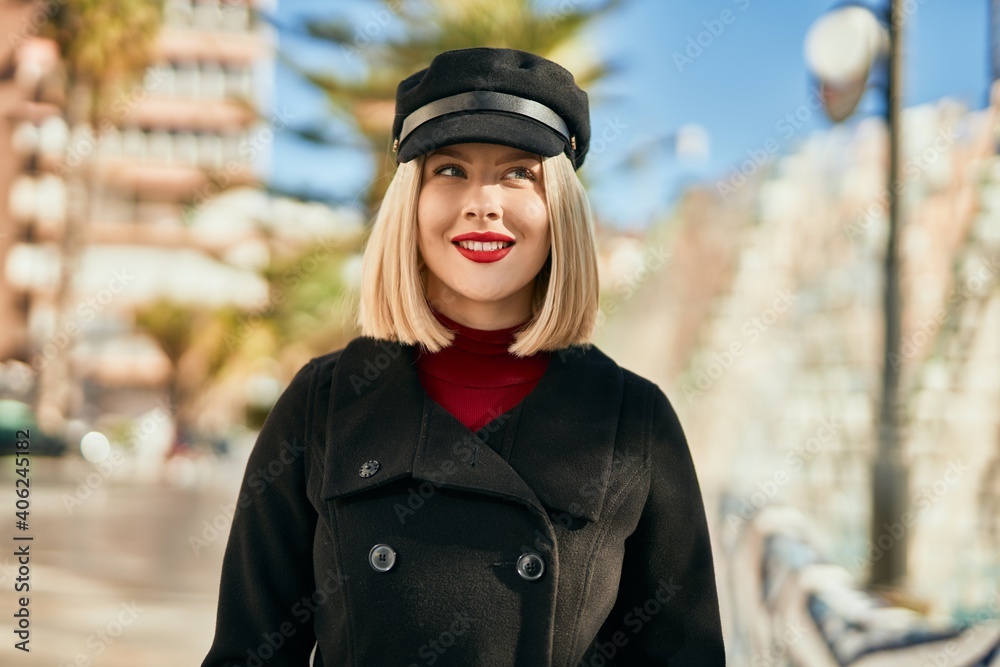 Young blonde woman smiling happy standing at the city.