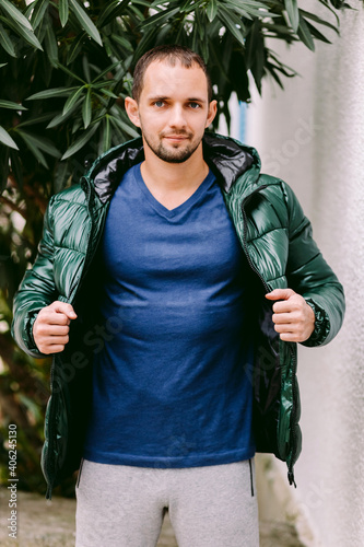 man wearing blue t-shirt mockup and jacket outdoors. Male in blank blue t-shirt v collar, front view outdoors. Design men t shirt template and mock-up for print 