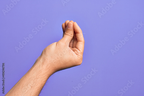 Hand of caucasian young man showing fingers over isolated purple background doing Italian gesture with fingers together, communication gesture movement