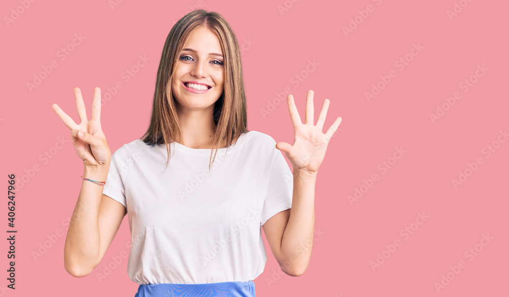 Young beautiful blonde woman wearing summer style showing and pointing up with fingers number eight while smiling confident and happy. Young beautiful blonde woman wearing summer style showing and pointing up with fingers number eight while smiling confident and happy.