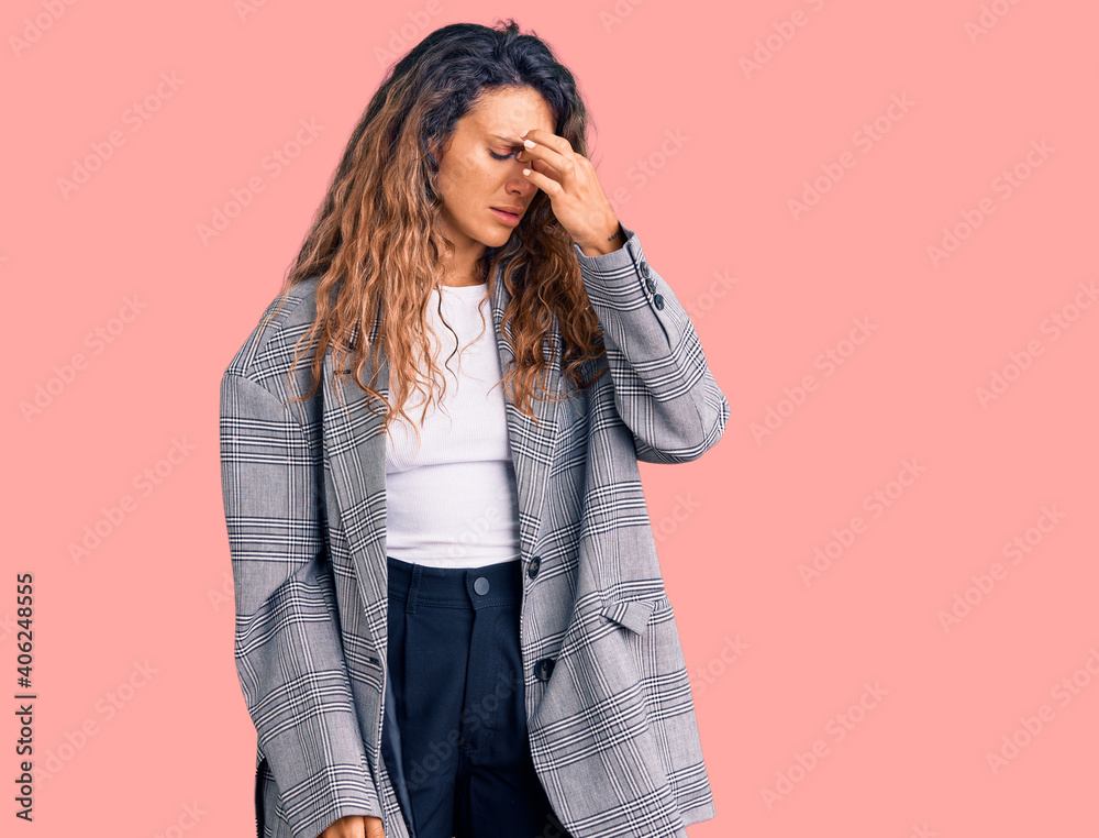 Young hispanic woman with tattoo wearing business oversize jacket tired rubbing nose and eyes feeling fatigue and headache. stress and frustration concept. Young hispanic woman with tattoo wearing business oversize jacket tired rubbing nose and eyes feeling fatigue and headache. stress and frustration concept.