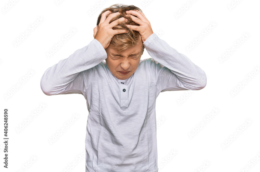Little caucasian boy kid wearing casual clothes suffering from headache desperate and stressed because pain and migraine. hands on head. Little caucasian boy kid wearing casual clothes suffering from headache desperate and stressed because pain and migraine. hands on head.