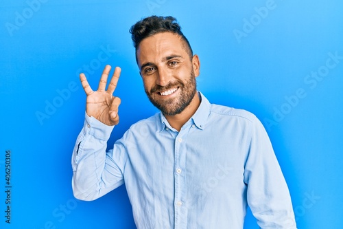 Handsome man with beard wearing casual clothes smiling positive doing ok sign with hand and fingers. successful expression.