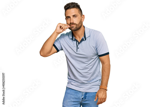 Handsome man with beard wearing casual clothes mouth and lips shut as zip with fingers. secret and silent, taboo talking