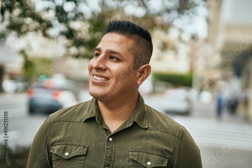 Young latin man smiling happy standing at the city.