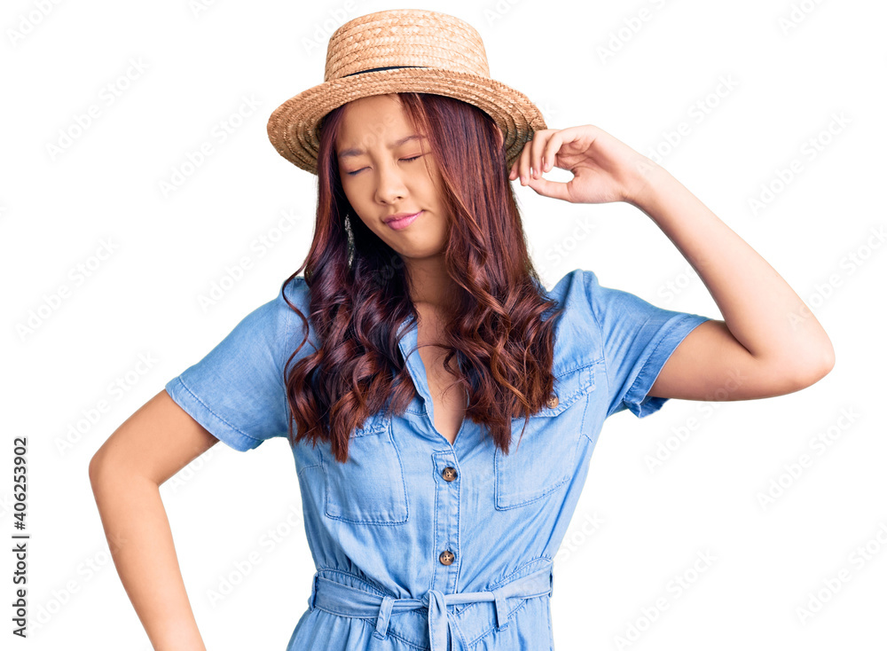 Young beautiful chinese girl wearing summer hat stretching back, tired and relaxed, sleepy and yawning for early morning Young beautiful chinese girl wearing summer hat stretching back, tired and relaxed, sleepy and yawning for early morning