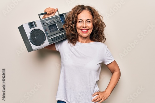 Middle age brunette hipster woman holding retro music boombox over isolated background looking positive and happy standing and smiling with a confident smile showing teeth