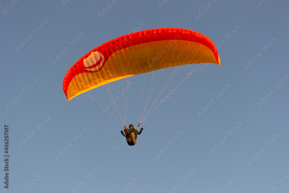 A beautiful view of a paraglide flying gliding on a clear blue sky at the golden hour with a nice wind windy breeze on a sunny day A beautiful view of a paraglide flying gliding on a clear blue sky at the golden hour with a nice wind windy breeze on a sunny day