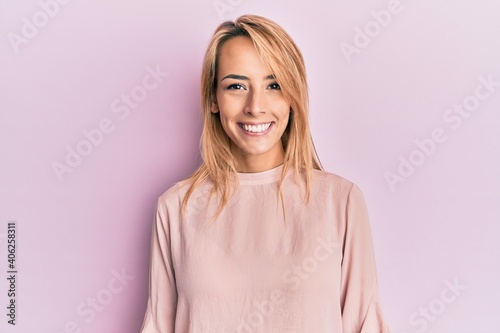 Beautiful blonde woman wearing casual winter sweater looking positive and happy standing and smiling with a confident smile showing teeth
