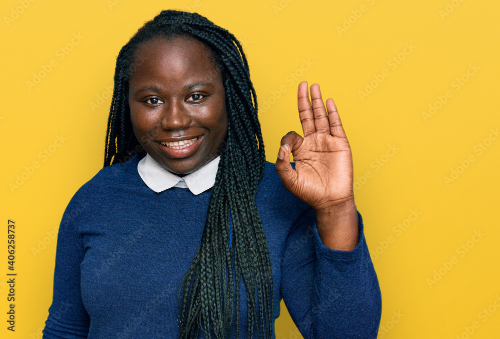 Young black woman with braids wearing casual clothes smiling positive doing ok sign with hand and fingers. successful expression. Young black woman with braids wearing casual clothes smiling positive doing ok sign with hand and fingers. successful expression.