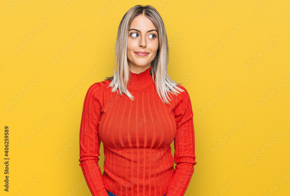Beautiful blonde woman wearing casual clothes smiling looking to the side and staring away thinking. Beautiful blonde woman wearing casual clothes smiling looking to the side and staring away thinking.