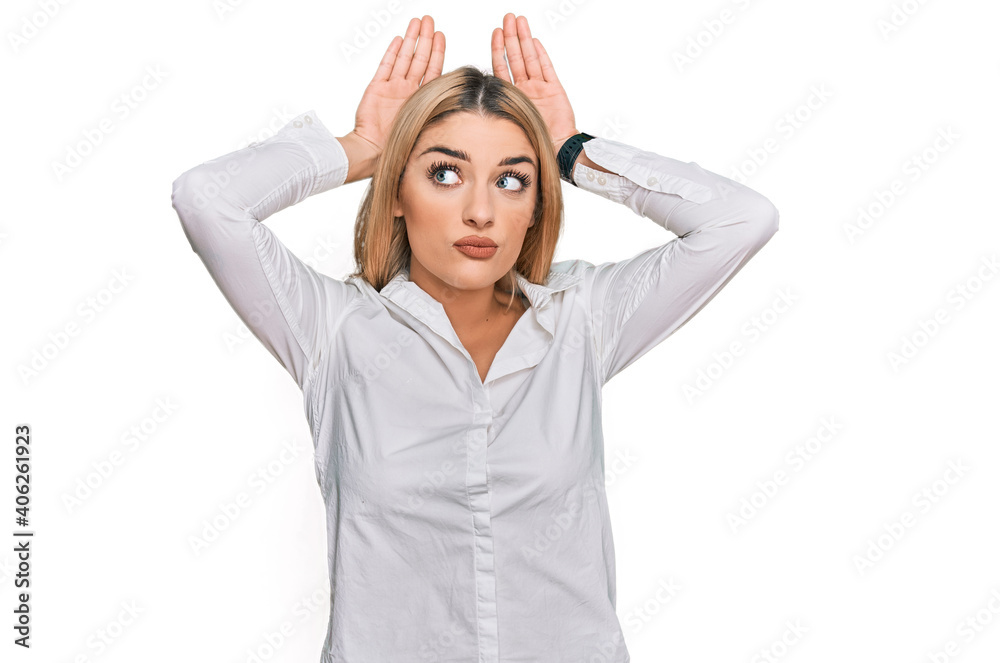 Young caucasian woman wearing casual clothes doing bunny ears gesture with hands palms looking cynical and skeptical. easter rabbit concept. Young caucasian woman wearing casual clothes doing bunny ears gesture with hands palms looking cynical and skeptical. easter rabbit concept.