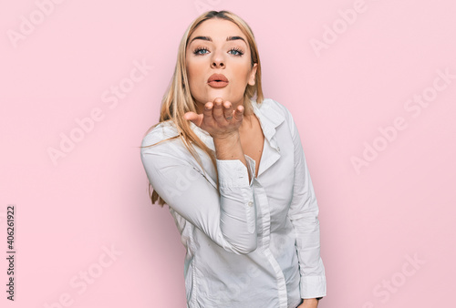 Young caucasian woman wearing casual clothes looking at the camera blowing a kiss with hand on air being lovely and sexy. love expression.