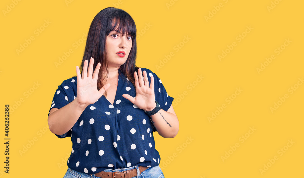 Young plus size woman wearing casual clothes moving away hands palms showing refusal and denial with afraid and disgusting expression. stop and forbidden. Young plus size woman wearing casual clothes moving away hands palms showing refusal and denial with afraid and disgusting expression. stop and forbidden.