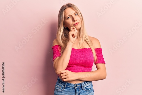 Young blonde woman wearing casual clothes thinking concentrated about doubt with finger on chin and looking up wondering
