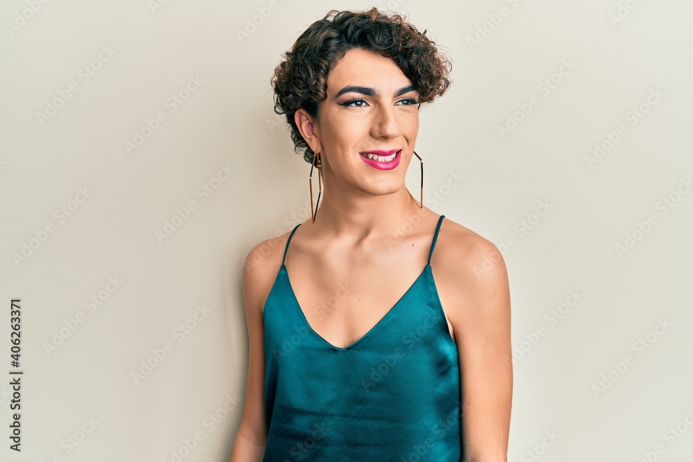 Young man wearing woman make up wearing party clothes looking to side, relax profile pose with natural face and confident smile. Young man wearing woman make up wearing party clothes looking to side, relax profile pose with natural face and confident smile.