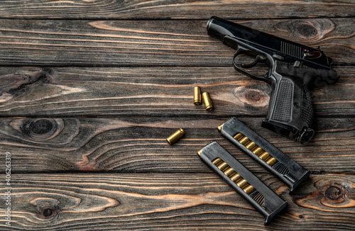 Εκτύπωση καμβά Pistol and cartridges for it on a wooden background