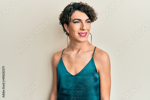 Young man wearing woman make up wearing party clothes looking to side, relax profile pose with natural face and confident smile.