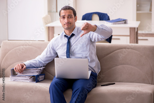 Young male employee working from home in pandemic concept