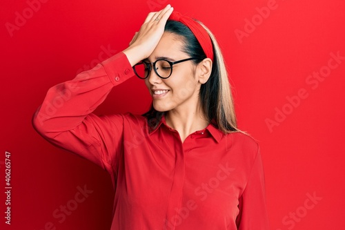 Young hispanic woman wearing casual clothes and glasses surprised with hand on head for mistake, remember error. forgot, bad memory concept. © Krakenimages.com