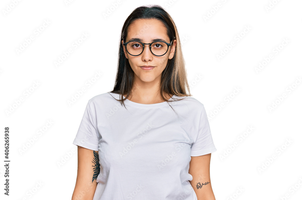 Young hispanic woman wearing casual white t shirt skeptic and nervous, frowning upset because of problem. negative person. Young hispanic woman wearing casual white t shirt skeptic and nervous, frowning upset because of problem. negative person.