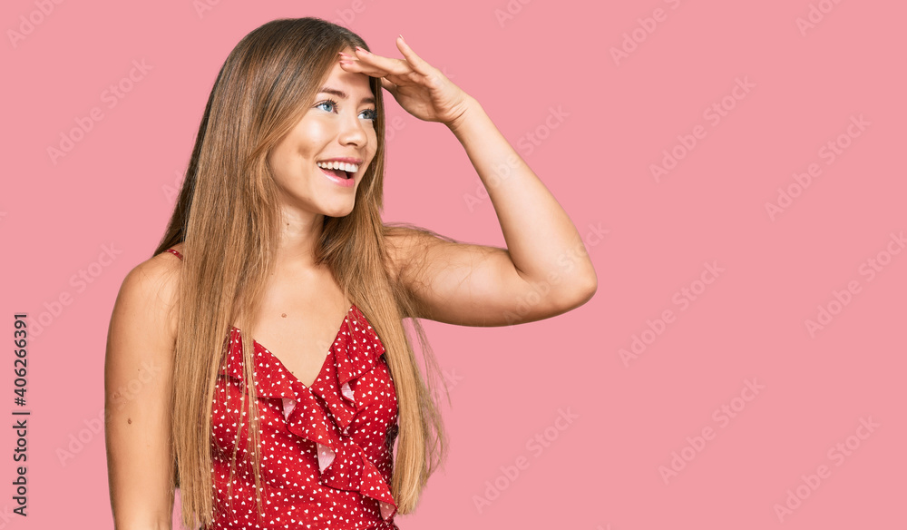 Beautiful blonde woman wearing summer dress very happy and smiling looking far away with hand over head. searching concept. Beautiful blonde woman wearing summer dress very happy and smiling looking far away with hand over head. searching concept.