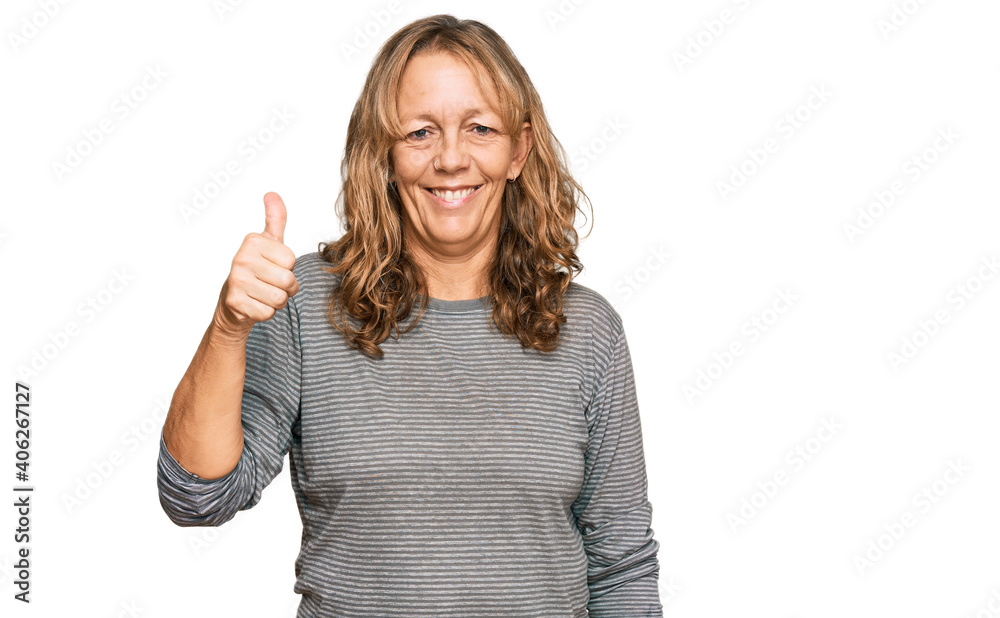 Middle age blonde woman wearing casual clothes smiling happy and positive, thumb up doing excellent and approval sign Middle age blonde woman wearing casual clothes smiling happy and positive, thumb up doing excellent and approval sign