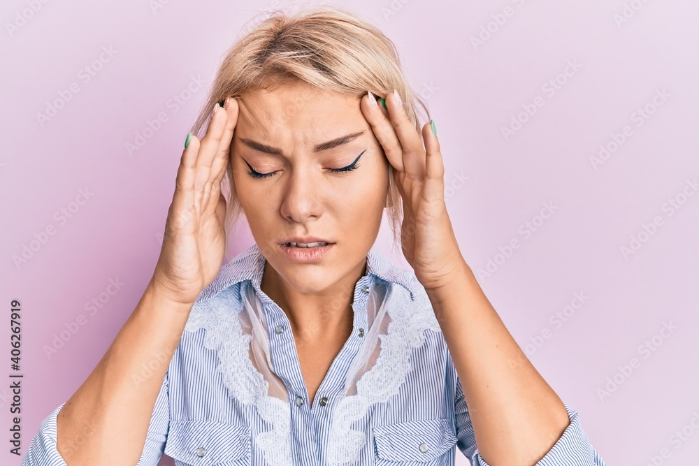 Young blonde girl wearing casual clothes with hand on head for pain in head because stress. suffering migraine. Young blonde girl wearing casual clothes with hand on head for pain in head because stress. suffering migraine.