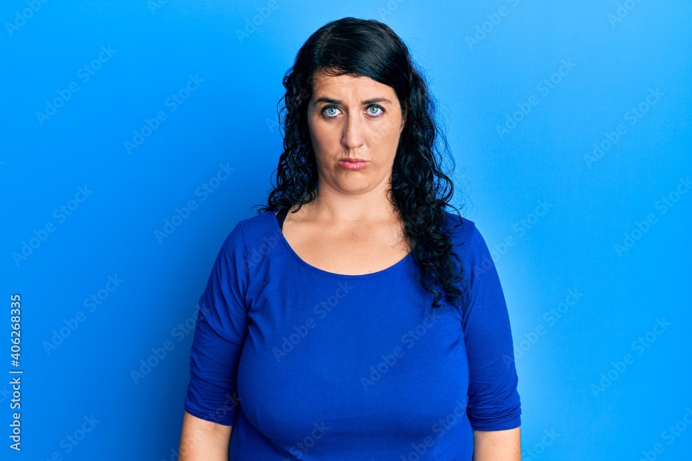 Plus size brunette woman wearing casual blue shirt depressed and worry for distress, crying angry and afraid. sad expression. Plus size brunette woman wearing casual blue shirt depressed and worry for distress, crying angry and afraid. sad expression.