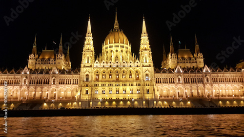 Horizontal shot of the Budapest Parliament building at night in front of the river photo