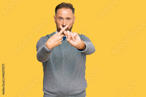 Handsome middle age man wearing business clothes rejection expression crossing fingers doing negative sign