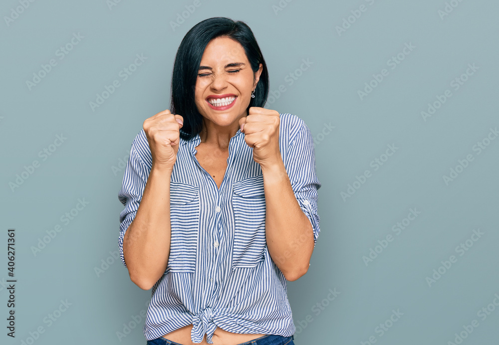 Young caucasian woman wearing casual clothes excited for success with arms raised and eyes closed celebrating victory smiling. winner concept. Young caucasian woman wearing casual clothes excited for success with arms raised and eyes closed celebrating victory smiling. winner concept.