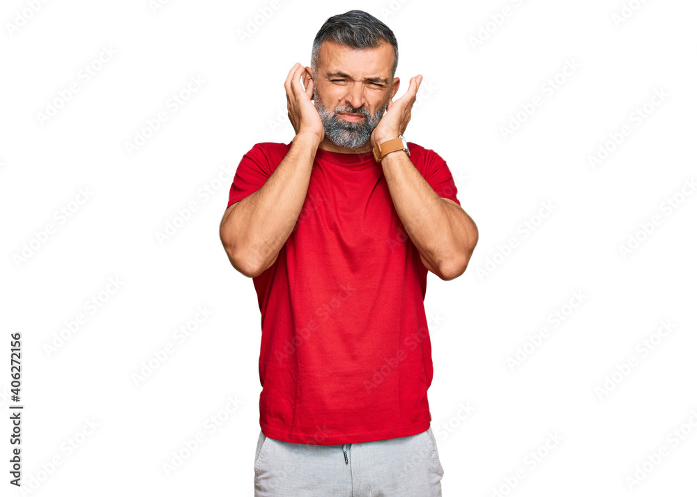 Middle age handsome man wearing casual clothes covering ears with fingers with annoyed expression for the noise of loud music. deaf concept. Middle age handsome man wearing casual clothes covering ears with fingers with annoyed expression for the noise of loud music. deaf concept.
