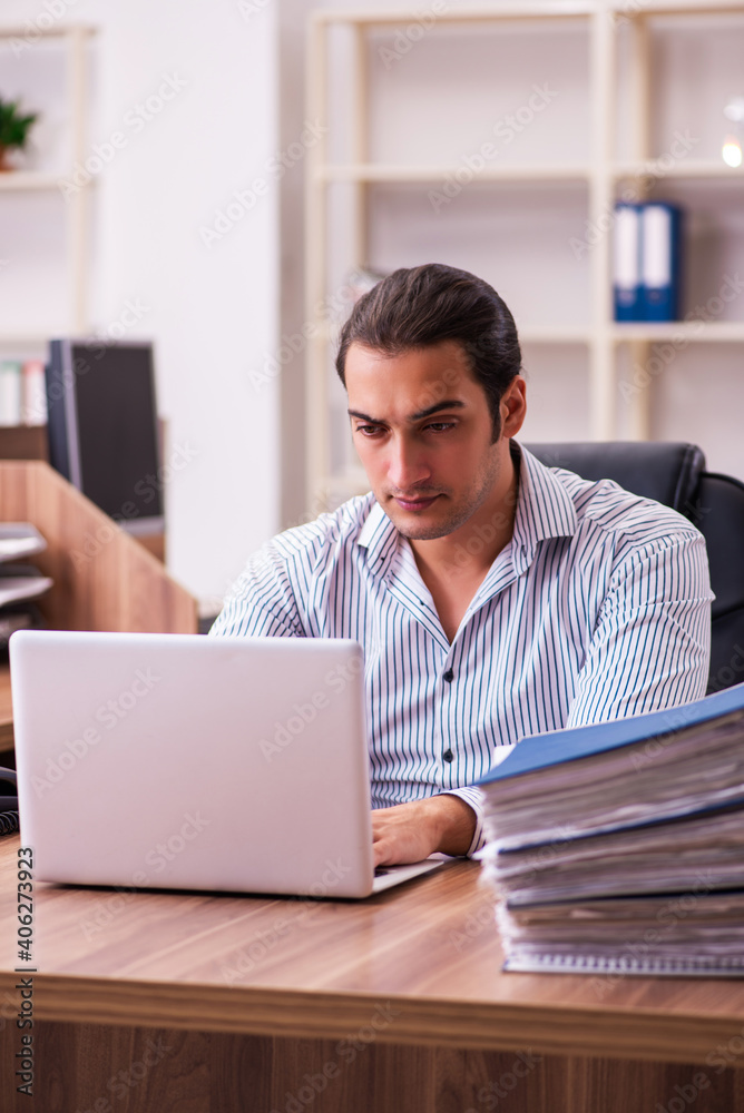 Young male employee working in the office Young male employee working in the office