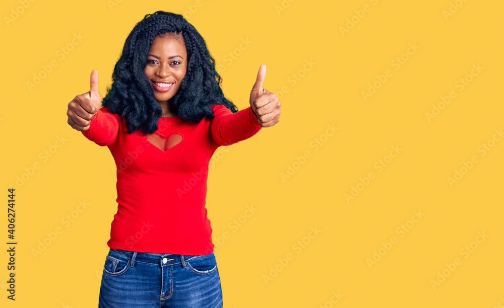 Beautiful african american woman wearing casual clothes approving doing positive gesture with hand, thumbs up smiling and happy for success. winner gesture. Beautiful african american woman wearing casual clothes approving doing positive gesture with hand, thumbs up smiling and happy for success. winner gesture.