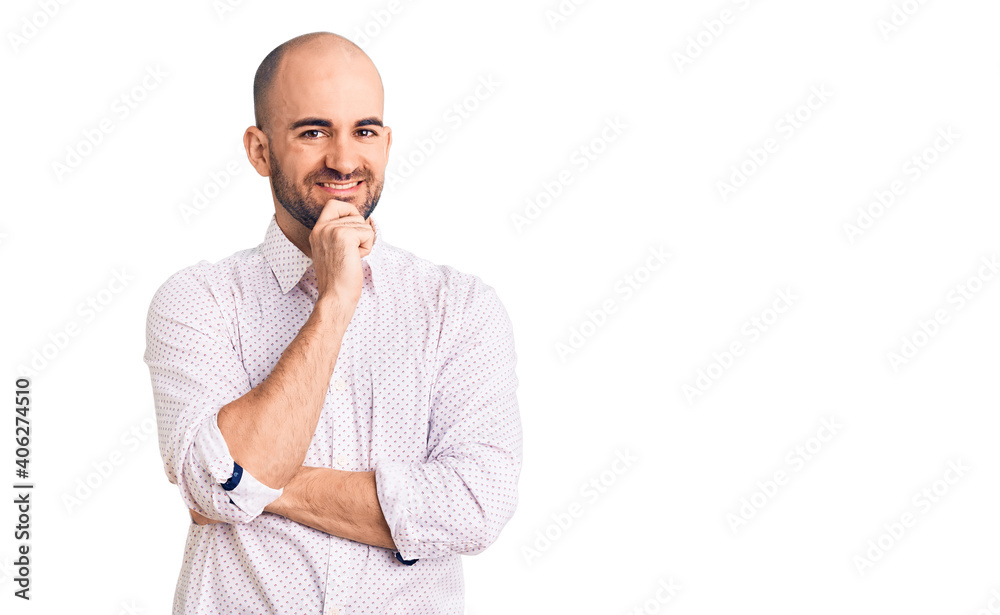 Young handsome man wearing elegant shirt looking confident at the camera with smile with crossed arms and hand raised on chin. thinking positive. Young handsome man wearing elegant shirt looking confident at the camera with smile with crossed arms and hand raised on chin. thinking positive.