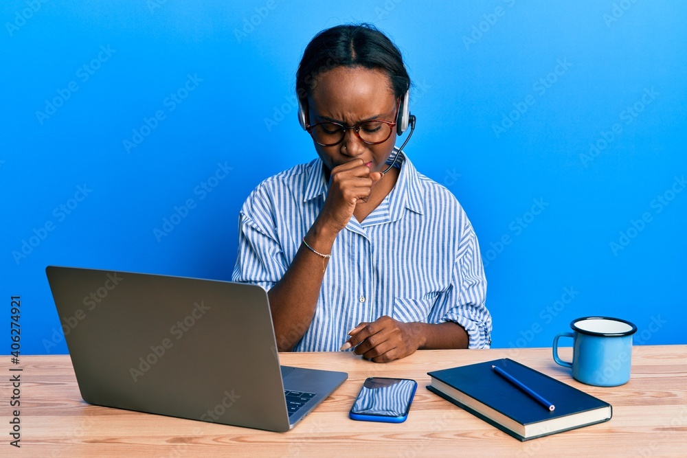Young african woman wearing call center agent headset feeling unwell and coughing as symptom for cold or bronchitis. health care concept. Young african woman wearing call center agent headset feeling unwell and coughing as symptom for cold or bronchitis. health care concept.