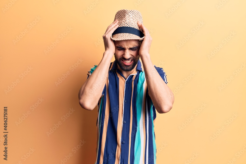 Young handsome man with beard wearing summer hat and shirt suffering from headache desperate and stressed because pain and migraine. hands on head. Young handsome man with beard wearing summer hat and shirt suffering from headache desperate and stressed because pain and migraine. hands on head.