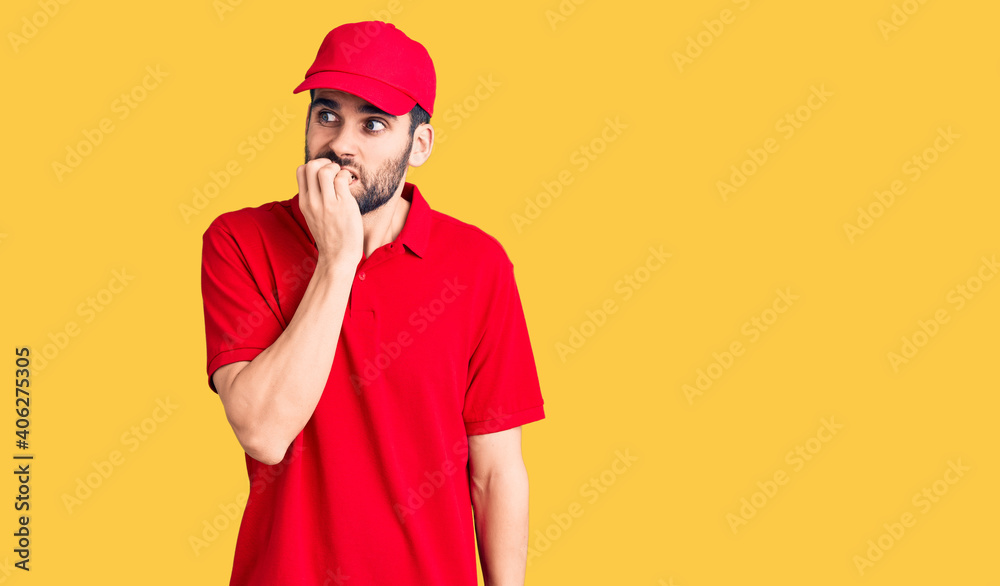 Young handsome man with beard wearing delivery uniform looking stressed and nervous with hands on mouth biting nails. anxiety problem.