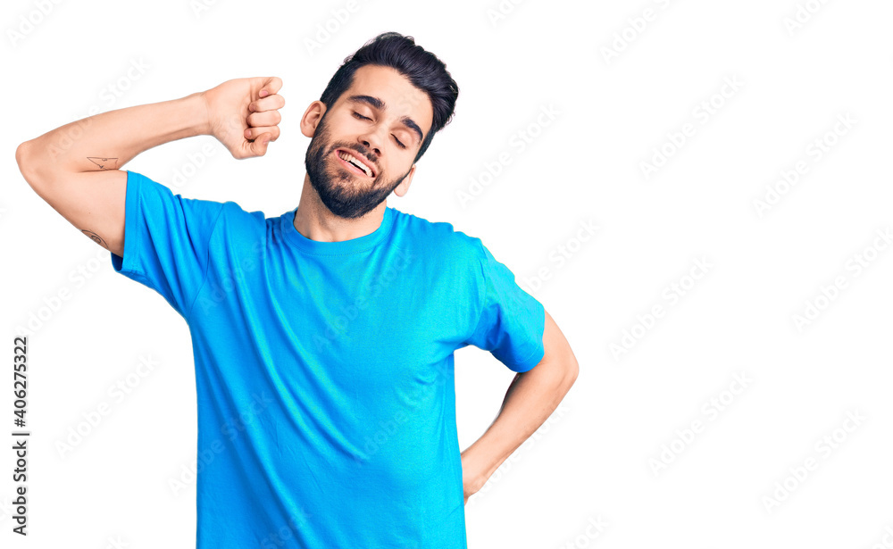 Young handsome man with beard wearing casual t-shirt stretching back, tired and relaxed, sleepy and yawning for early morning Young handsome man with beard wearing casual t-shirt stretching back, tired and relaxed, sleepy and yawning for early morning