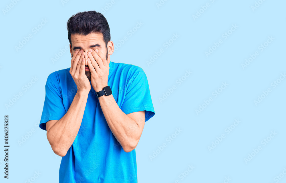 Young handsome man with beard wearing casual t-shirt rubbing eyes for fatigue and headache, sleepy and tired expression. vision problem Young handsome man with beard wearing casual t-shirt rubbing eyes for fatigue and headache, sleepy and tired expression. vision problem
