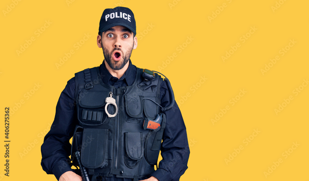 Young handsome man with beard wearing police uniform afraid and shocked with surprise expression, fear and excited face. Young handsome man with beard wearing police uniform afraid and shocked with surprise expression, fear and excited face.