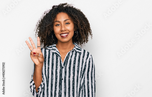 Young african american girl wearing casual clothes showing and pointing up with fingers number three while smiling confident and happy. © Krakenimages.com