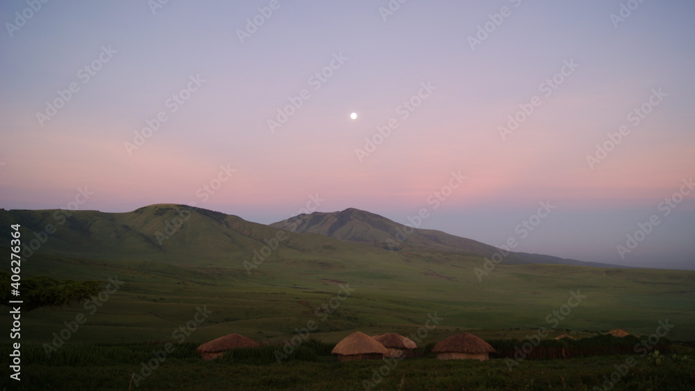 Early morning moon over a Maasai village.  East Africa.